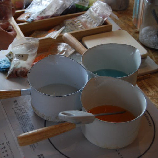 Hand-poured Japanese candle certificate course student making colors for pillar candle