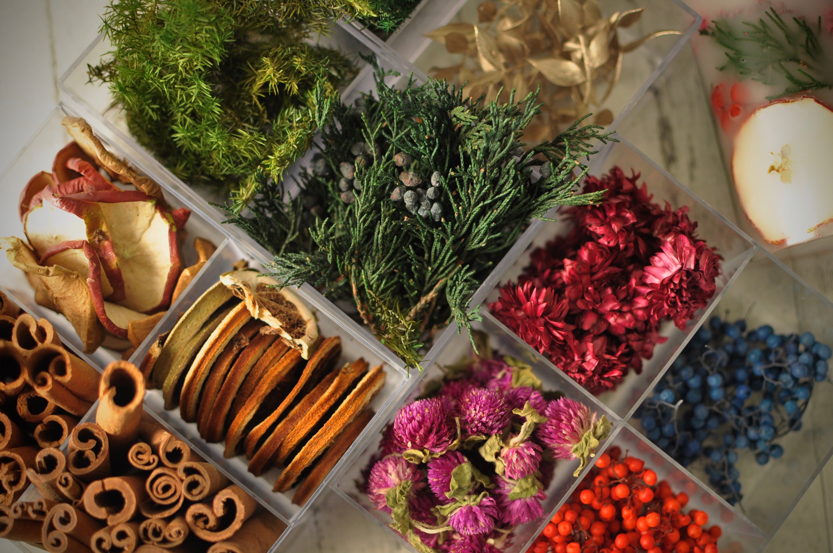 Candle making kit with wax, fragrance oils, and dried flowers neatly arranged.